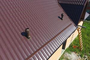 luft kanaler på metall tak. de tak av korrugerad ark. takläggning av metall profil vågig form foto