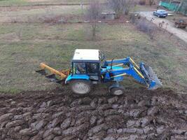 traktor plöjning de trädgård. plöjning de jord i de trädgård foto