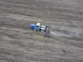 odling av jord för de sådd av spannmål. traktor plogar de jord på de fält foto