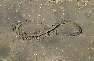 de tecken av oändlighet på de hav. kust sand på de strand. de symbol av oändlighet foto