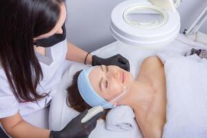 ung skön kvinna få ansiktsbehandling behandling i spa salong. skönhet behandling begrepp. foto