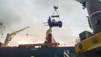 rör på sig de gaffeltruck lastbil från de däck av de hamn till de fartyg använder sig av en kran. service fordon foto