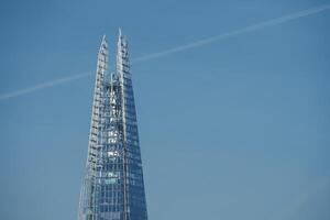 solbelyst skärva, de ikoniska skyskrapa, står mot londons blå himmel, Storbritannien. foto