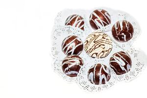 uppsättning av runda choklad godis, dekorerad med rader av vit grädde foto