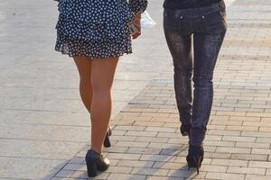 kvinnors ben i strumpor och jeans. lätt promenad längs de trottoar foto