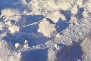 klumpar av snö i vinter. snö och ljus under de dag. snödrivor. foto