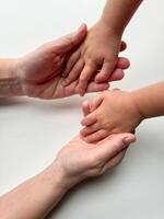 kvinnors gest med barnets hand på vit yta foto