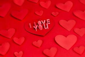 valentine kort med text jag kärlek du. deklaration av kärlek. kärlek brev, röd papper hantverk hjärtan röd bakgrund, textur foto