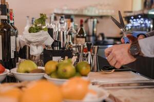 professionell bartender skärande färsk orange med sax i Venedig bar, cocktail förberedelse begrepp foto