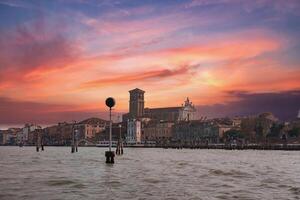lugn venetian gondol flytande på klar vatten med stadsbild i de bakgrund foto