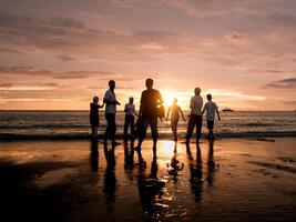 silhuett av människor de strand under solnedgång foto