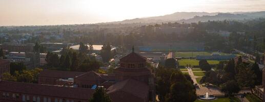 antenn soluppgång eller solnedgång se av ucla campus med frodig grönska, olika arkitektur, och dimmig bergen foto