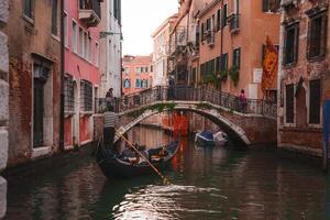 lugn svart gondol på upptagen Venedig kanal, fångande de stadens unik charm. foto