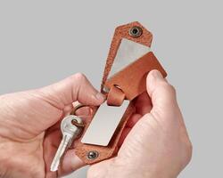beställnings- brun läder nyckel hållare med tryckt Foto i manlig händer