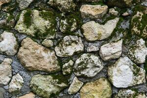 bakgrund, textur - mossiga grov murverk från naturlig sten foto