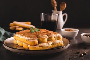 tiramisu klassisk efterrätt med småkakor, mascarpone och kaffe på en tallrik på de tabell foto