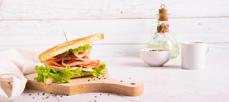 smörgås med skinka, ost och lök på en trä- styrelse på de tabell webb baner foto