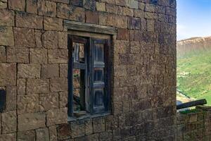 gammal trä- fönster med jalusier i de ruiner av de övergiven by av gamsutl, dagestan foto