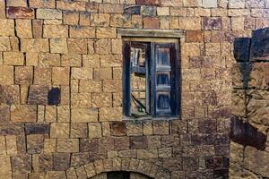 gammal trä- fönster med jalusier i de ruiner av de övergiven by av gamsutl, dagestan foto