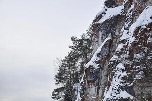 snö klippa mot de vinter- himmel foto