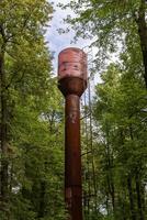 gammal metall vatten torn i de skog foto