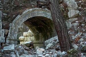 förfallen båge - ingång till de antik teater i de ruiner av de gammal stad av olympos, Kalkon foto