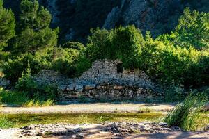 ruiner av gammal byggnader på de bakgrund av bergen i de antik stad av olympos, Kalkon foto