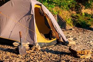 vandra läger på en klippig Strand, kupol ram tält foto
