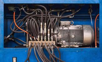 elektrisk motor, pump och kontrollera ventiler med slangar av en hydraulisk maskin stänga upp foto