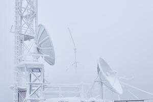 frostig parabolisk antenner och de källare av de cell torn på de bas radio station belägen i de highlands foto