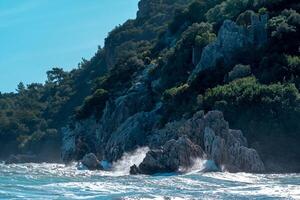 hav surfa på en klippig trädbevuxen tropisk havsstrand med fästning ruiner foto