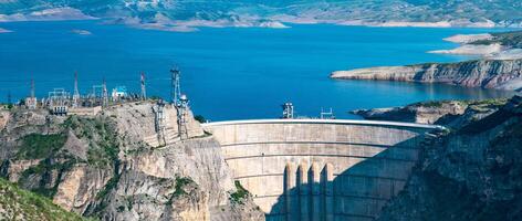 övre del av enorm båge damm av de vattenkraft kraft station och de elektrisk substation i en hög berg kanjon, de chirkeyskaya hpp i dagestan foto