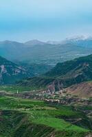 dimmig alpina dal med byar och fält mellan berg toppar i dagestan foto