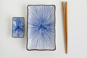 ett bild av blå keramisk tallrik uppsättning för sushi med trä- ätpinnar. foto