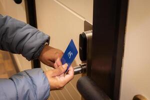 kvinna hand använder sig av elektronisk smart nyckel kort till låsa upp dörr i hotell eller hus. digital låsa, dörr tillgång kontrollera, kontaktlös begrepp. närbild, kopia Plats foto