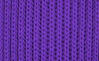 textur av stickat ull tyg med av en lila Färg med mönster. topp se. närbild. selektiv fokus. foto
