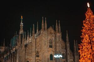 milano, Italien 18.12.2023 i vinter. jul träd i främre av milan katedral, duomo fyrkant i december, kväll se. jul högtider i milano. jul och ny år begrepp foto