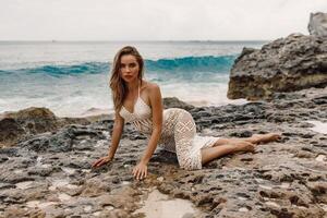 skön ung kvinna i klänning Framställ på tropisk strand foto