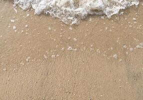 vit bubbla av hav Vinka på bra sand på de strand foto