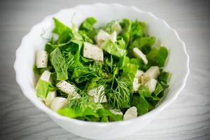 färsk grön sallad sallad med mozzarella och örter i en skål foto