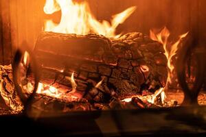 logga av trä brinnande i en öppen spis inuti en hus, härd foto