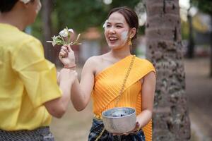 en skön ung thai par bär thai kostymer spelar i de vatten under songkran i de tempel foto