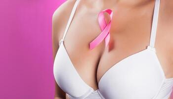 skön kvinna bröst i en vit behå med en rosa band på henne bröst. de begrepp av Stöd för cancer patienter. närbild - rosa bakgrund. foto