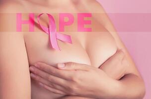 hoppas begrepp - naken kvinna med rosa bröst cancer medvetenhet band. Stöd av patienter med onkologi foto