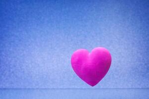 enkel blå bakgrund med liten violett röd hjärta foto