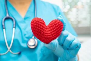 läkare som håller ett rött hjärta på sjukhusavdelningen, friskt starkt medicinskt koncept. foto
