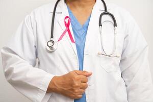 bröst cancer, asiatisk läkare kvinna med rosa band, symbol av värld bröst cancer dag. foto