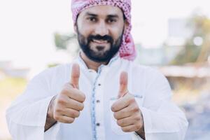 arub muslim vuxen manlig Lycklig leende tummen upp ser närbild foto