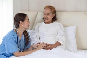 sjuksköterska ta vård patient äldre senior kvinna talande tröst återhämtning på säng på Hem foto