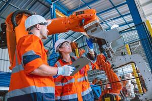 ingenjör lagarbete arbetssätt i automatisering fabrik service program robot ärm svetsning hopsättning foto